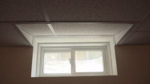 Picture of finished suspended ceiling window well slope in basement